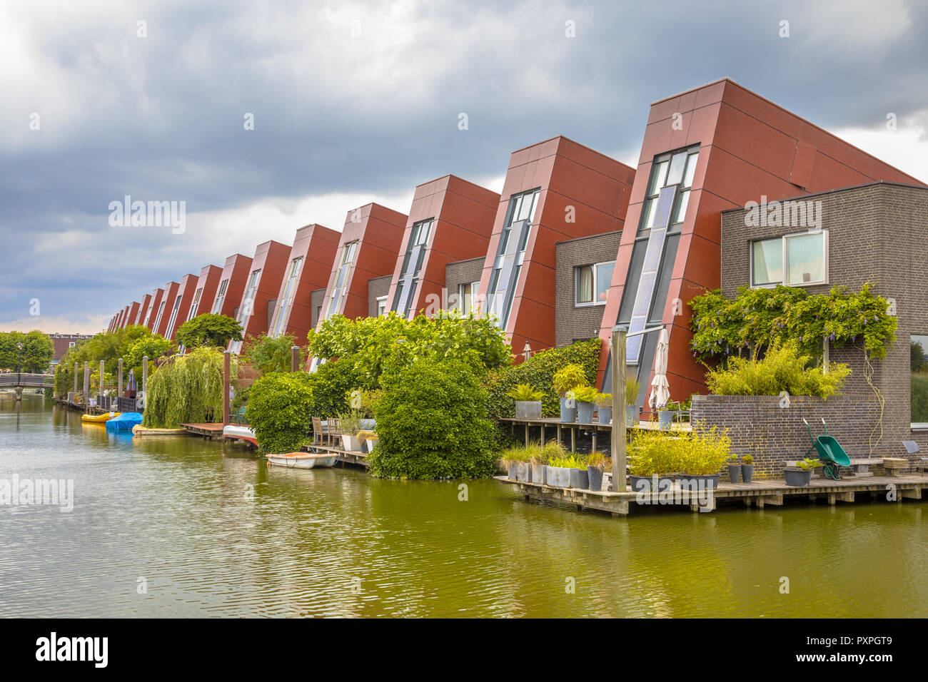 Ecological houses with integrated solar panels and hanging gardens on waterfront in urban area of The Hague, Netherlands Stock Photo