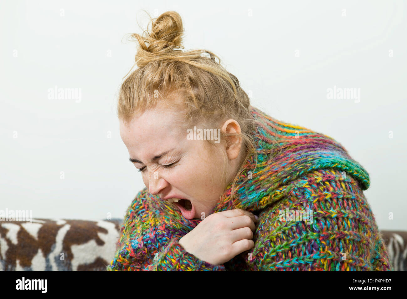 Young woman sick in bed wearing sweater. Illness Stock Photo