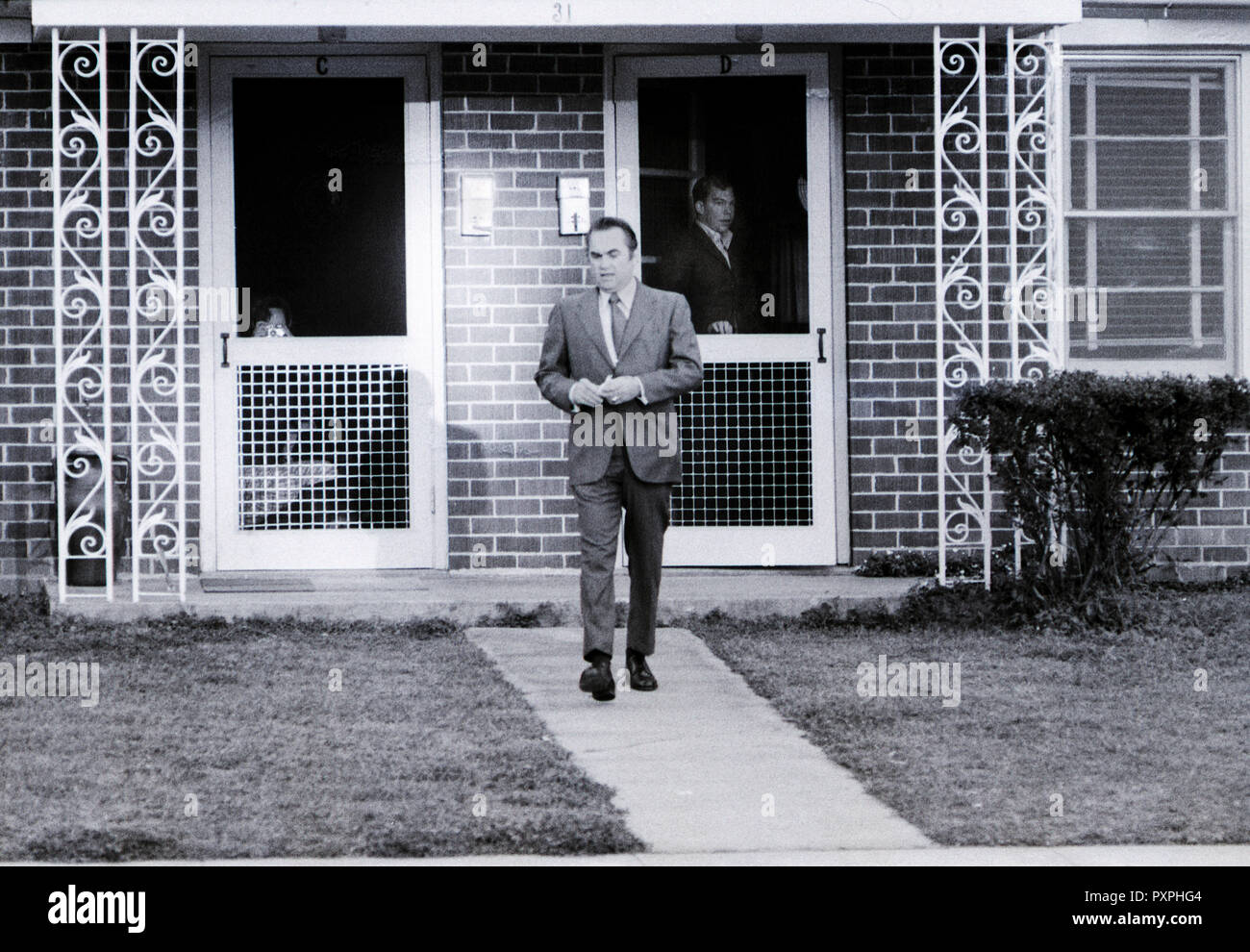 Lt. William Calley peers from his door as Alabama Governor George Wallace leaves after a visit to Calley who is currently under house arrest on post at Ft. Benning, Ga.. William Laws Calley Jr. is a former United States Army officer convicted by court-martial of murdering 22 unarmed South Vietnamese civilians in the My Lai Massacre on March 16, 1968, during the Vietnam War. Calley's next door neighbor snaps a photo of the governor's departure. Stock Photo