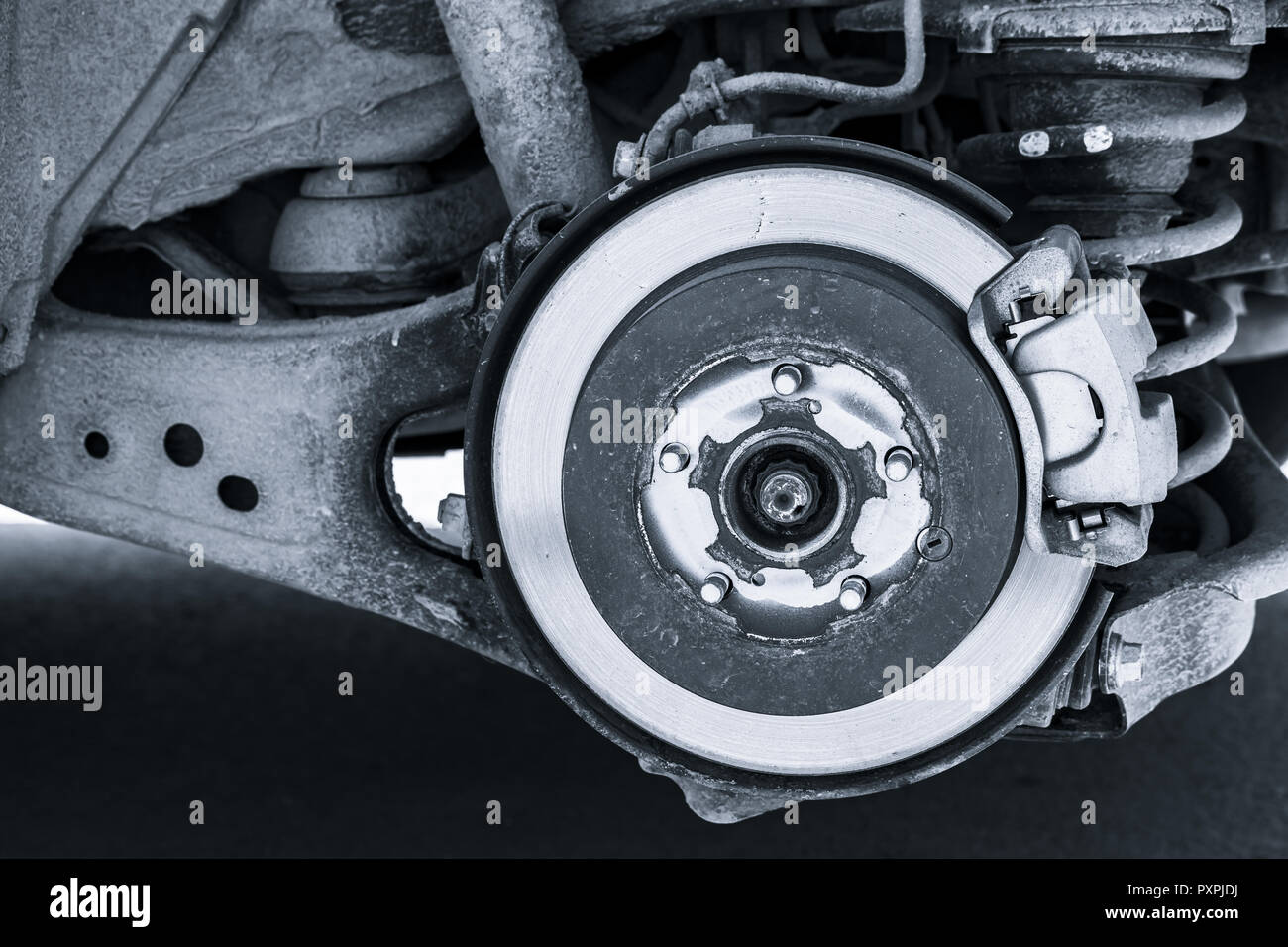 Shiny brake disk and suspension spring. Replacing wheel on SUV car