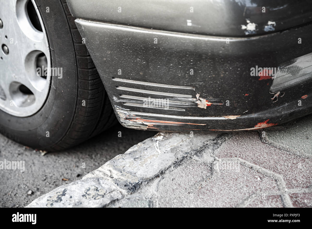 Damaged front car bumper with scratches, close-up photo Stock Photo
