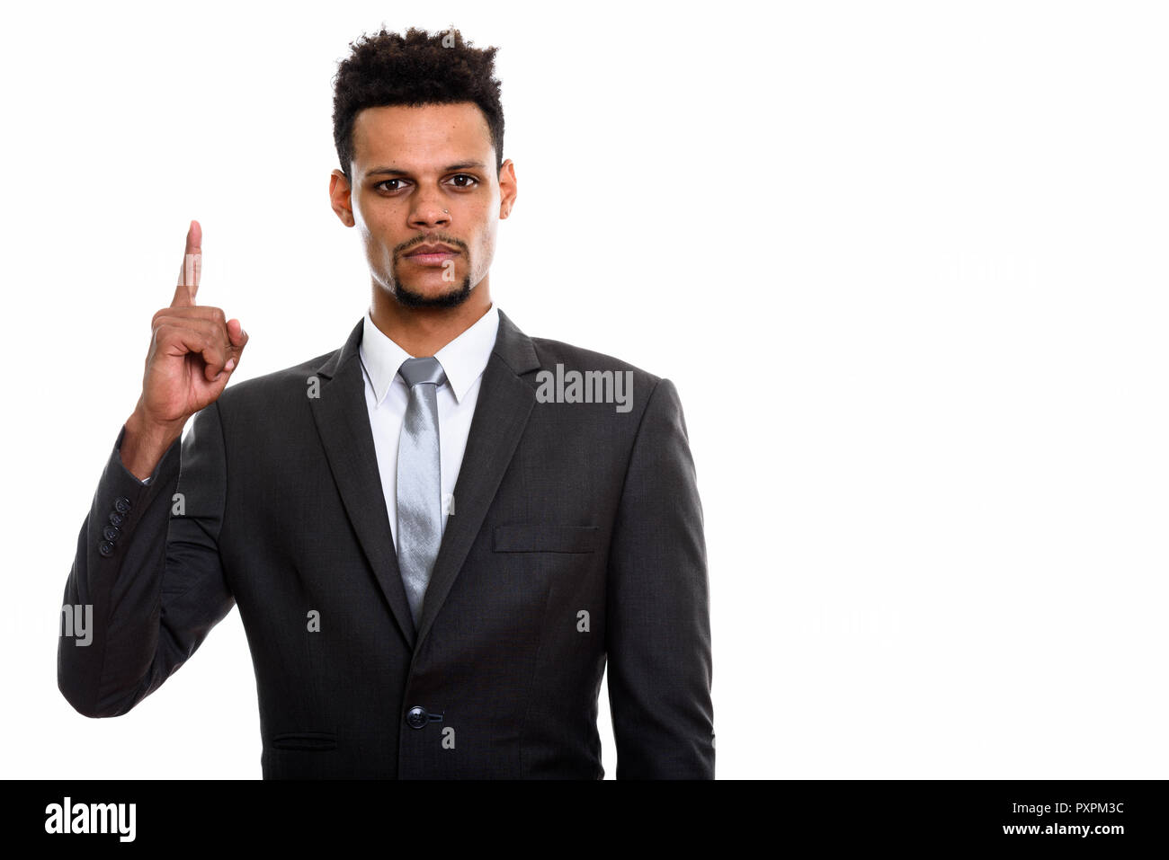 Studio shot of young African businessman pointing finger up  Stock Photo