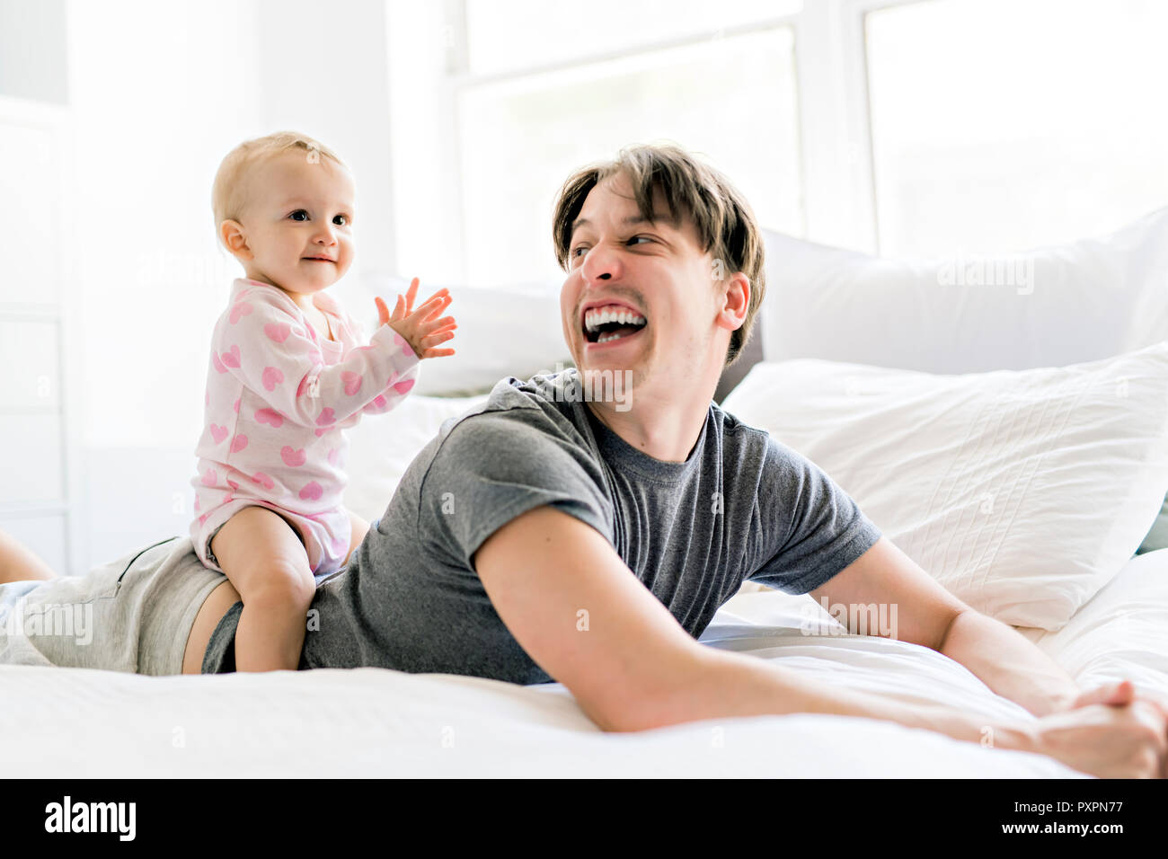 Happy father with baby lying on bed at home Stock Photo - Alamy
