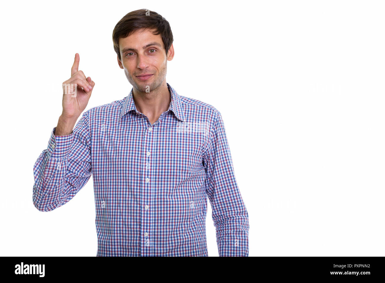 Studio shot of young handsome businessman pointing finger up Stock Photo
