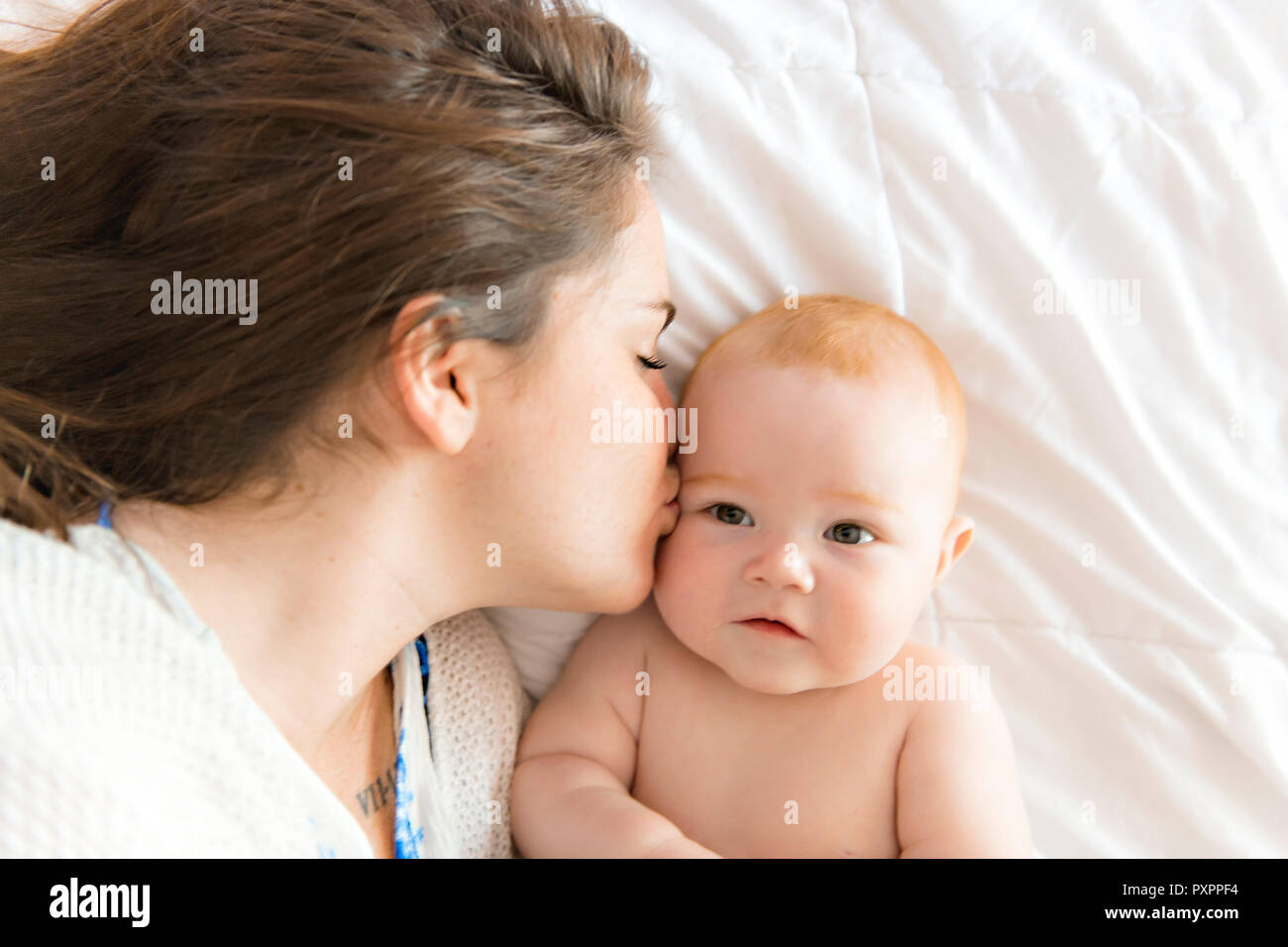 happy mother with baby in bed at home Stock Photo Alamy