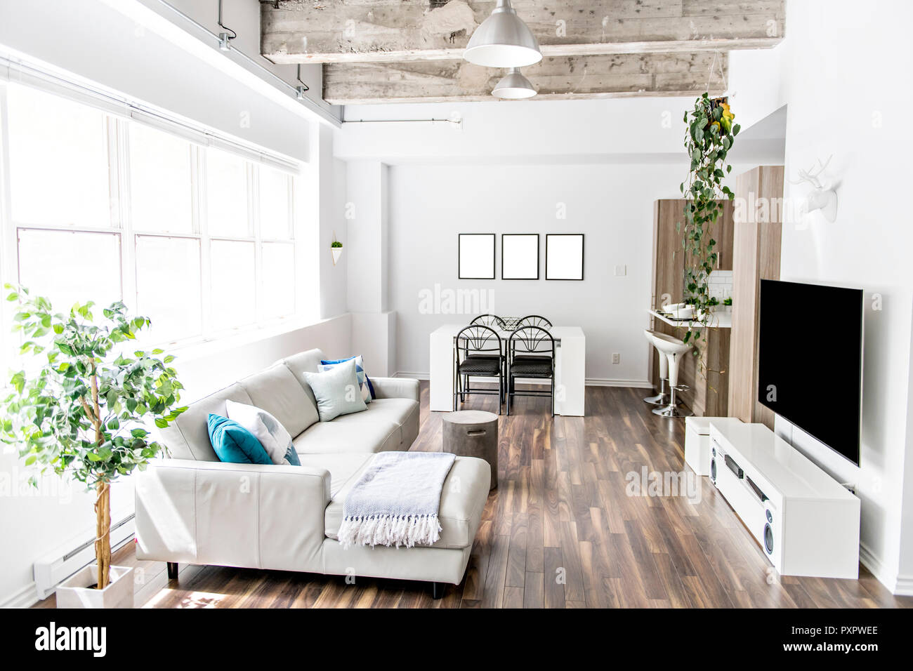 Apartment with big window sofa, table tv and concreate ceiling Stock Photo