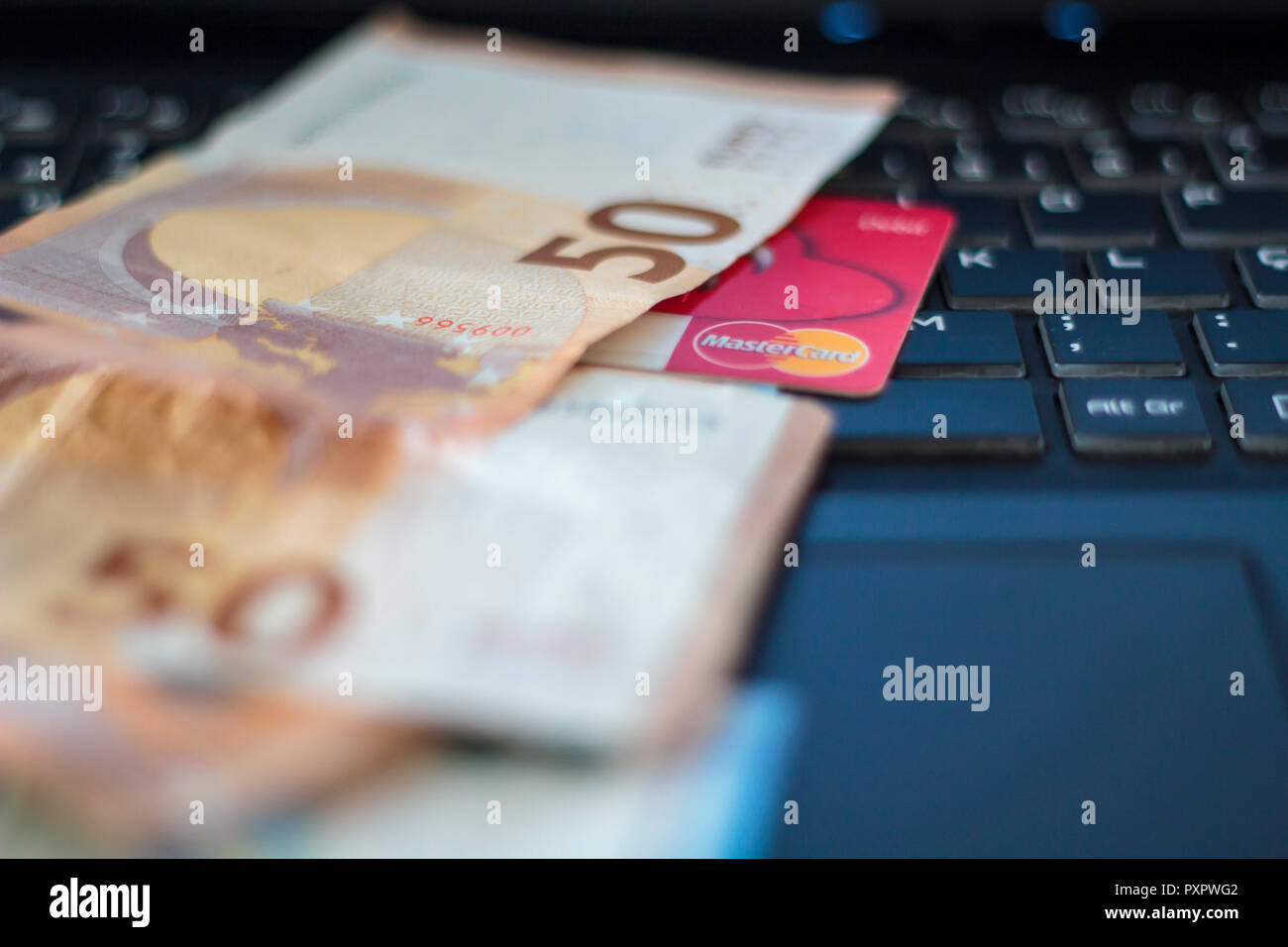 Euro banknotes and credit card on laptop computer Stock Photo - Alamy