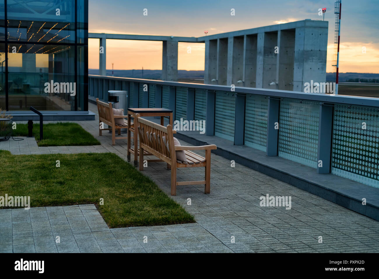 Modern Rooftop Patio With Wooden Benches In Evening Stock Photo