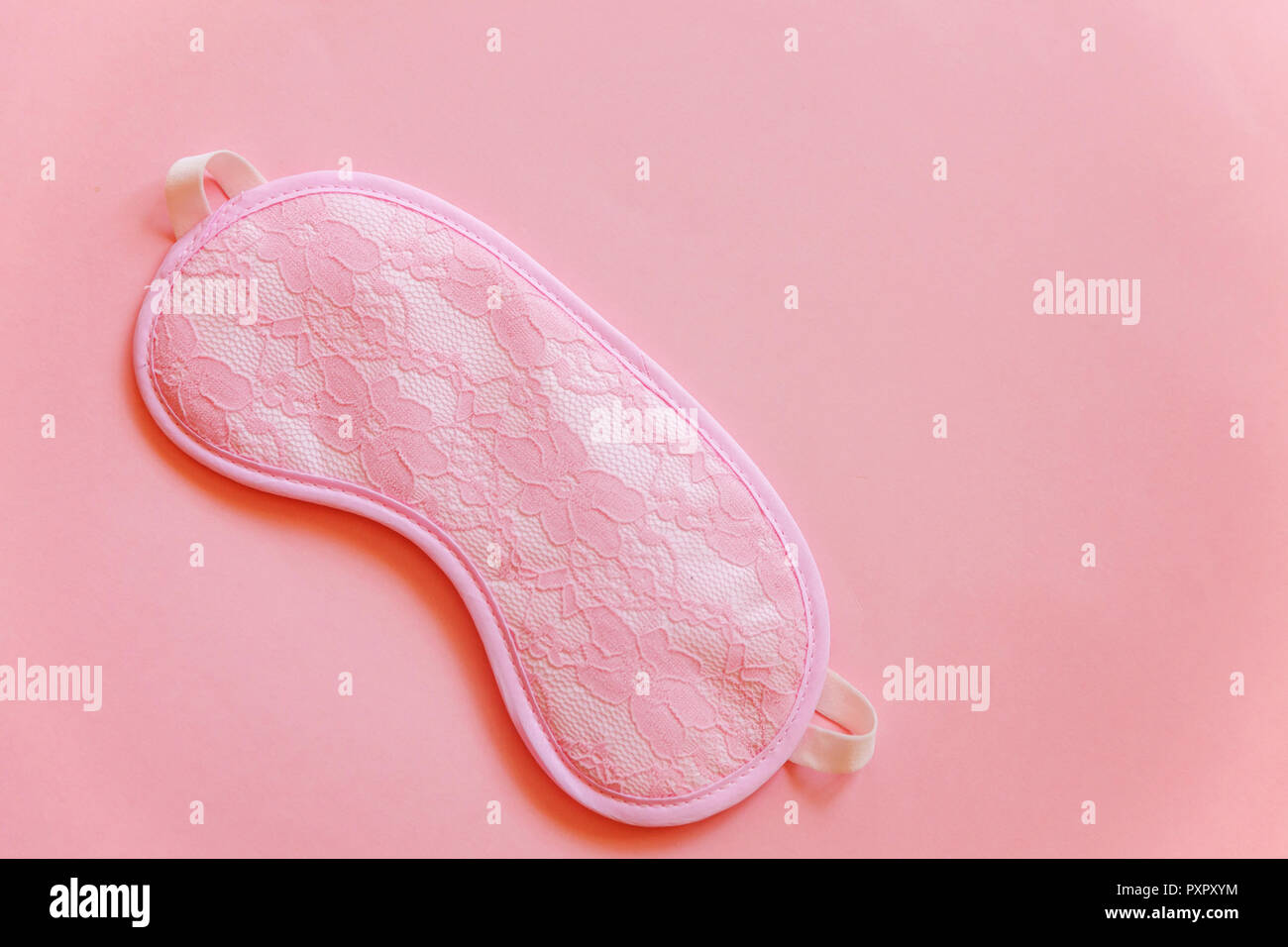 Sleeping eye mask, isolated on pink pastel colourful trendy background. Do not disturb me, let me sleep. Rest, good night, insomnia, relaxation, tired Stock Photo