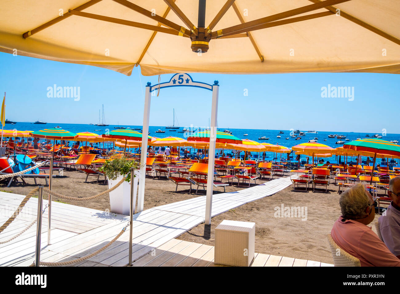 Colourful parasol multi-coloured umbrellas lounger beach beds, stripe  parasols bright beach, positano, campania italy, travel concept, tourist  concept Stock Photo - Alamy