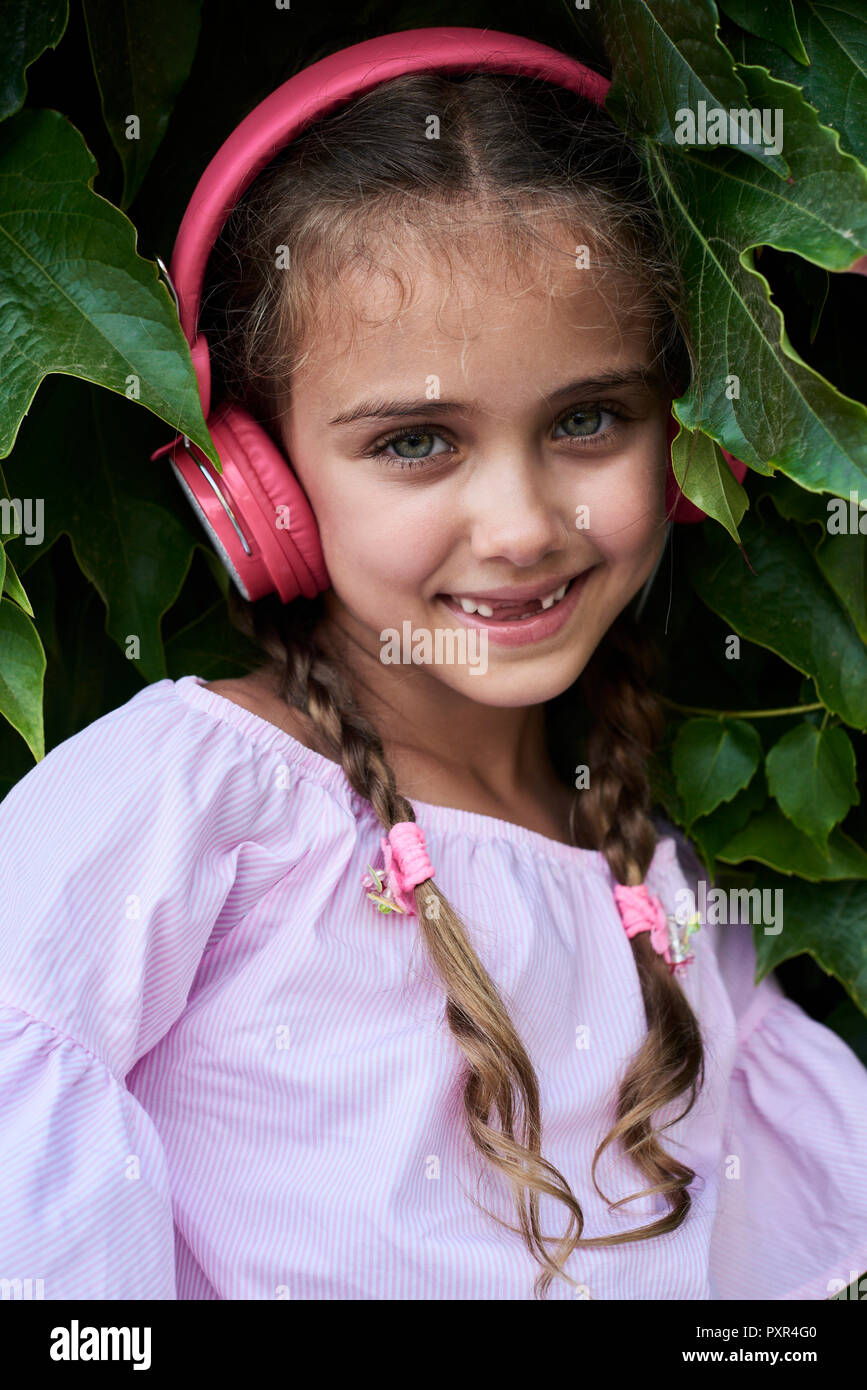 Little girl portrait wearing pink outfit and headphones Stock Photo