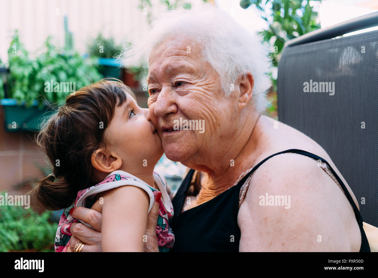 Baby Girl Kissing Her Grandmother On Terrace Stock Photo Alamy