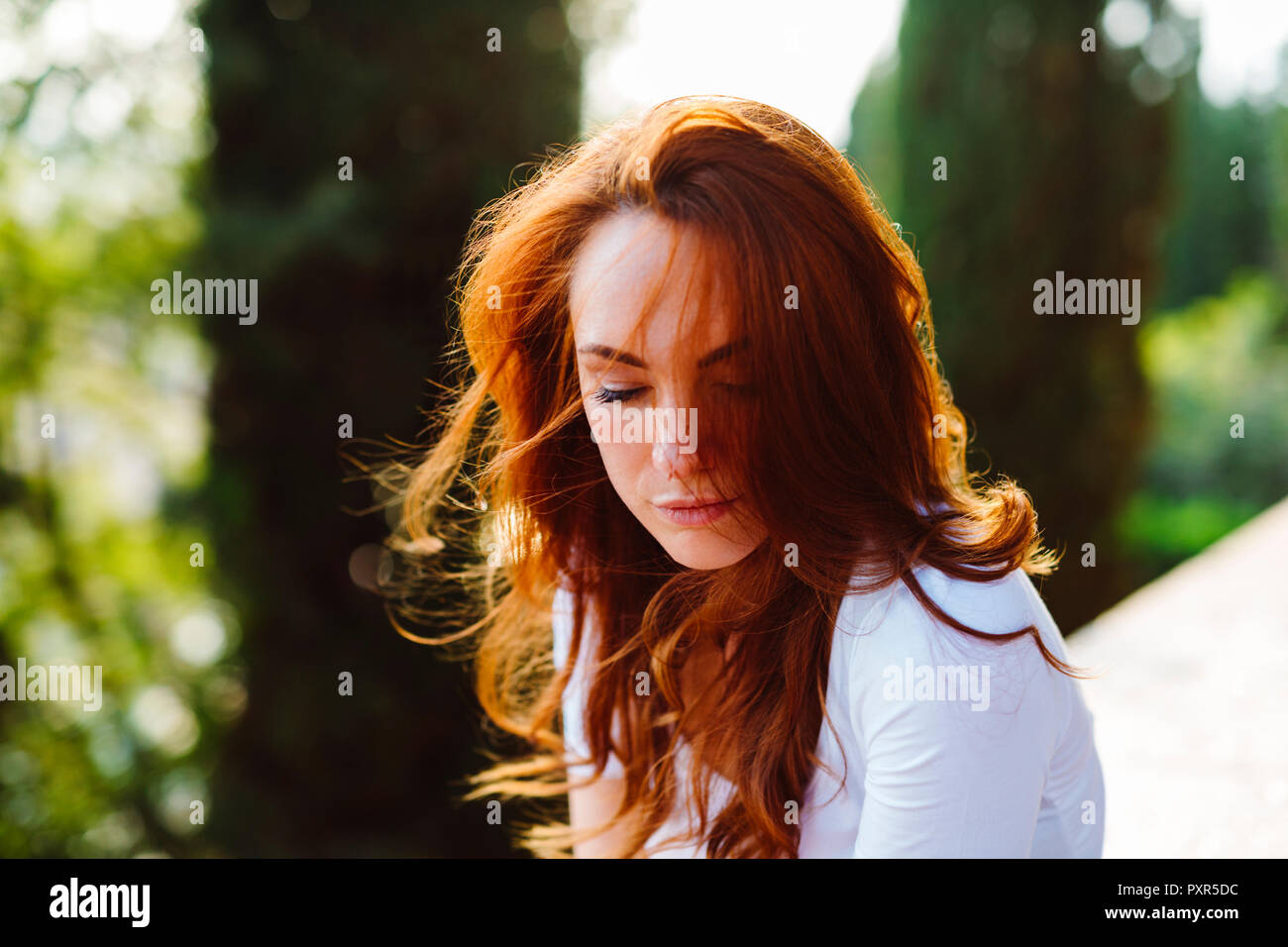 Portrait of redheaded woman at backlight Stock Photo