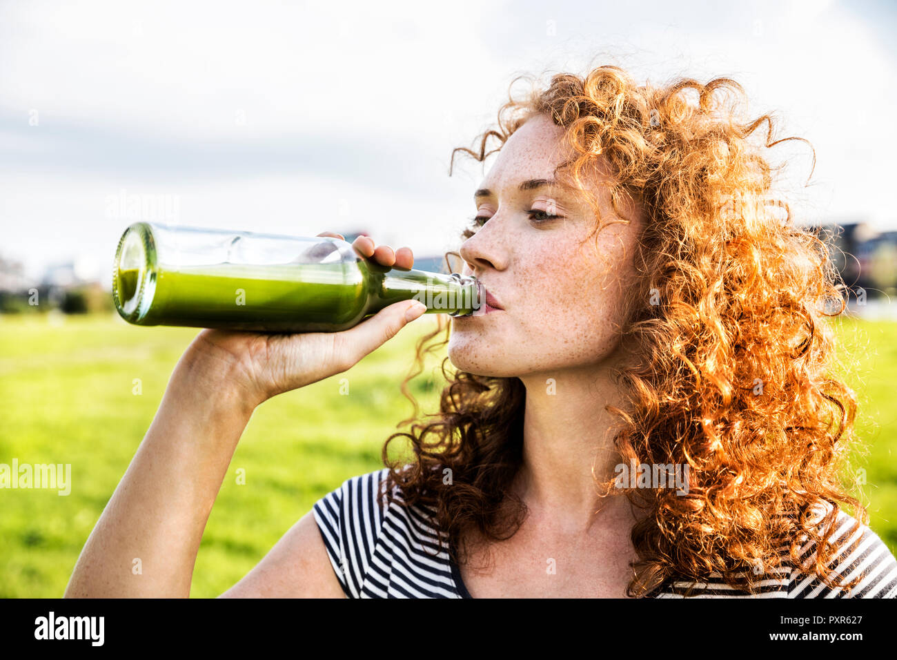Portrait of redheaded young woman drinking beverage Stock Photo