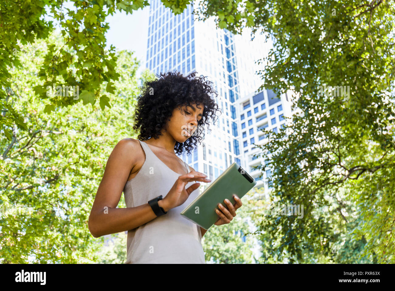 Germany, Frankfurt, young woman using tablet in the city Stock Photo