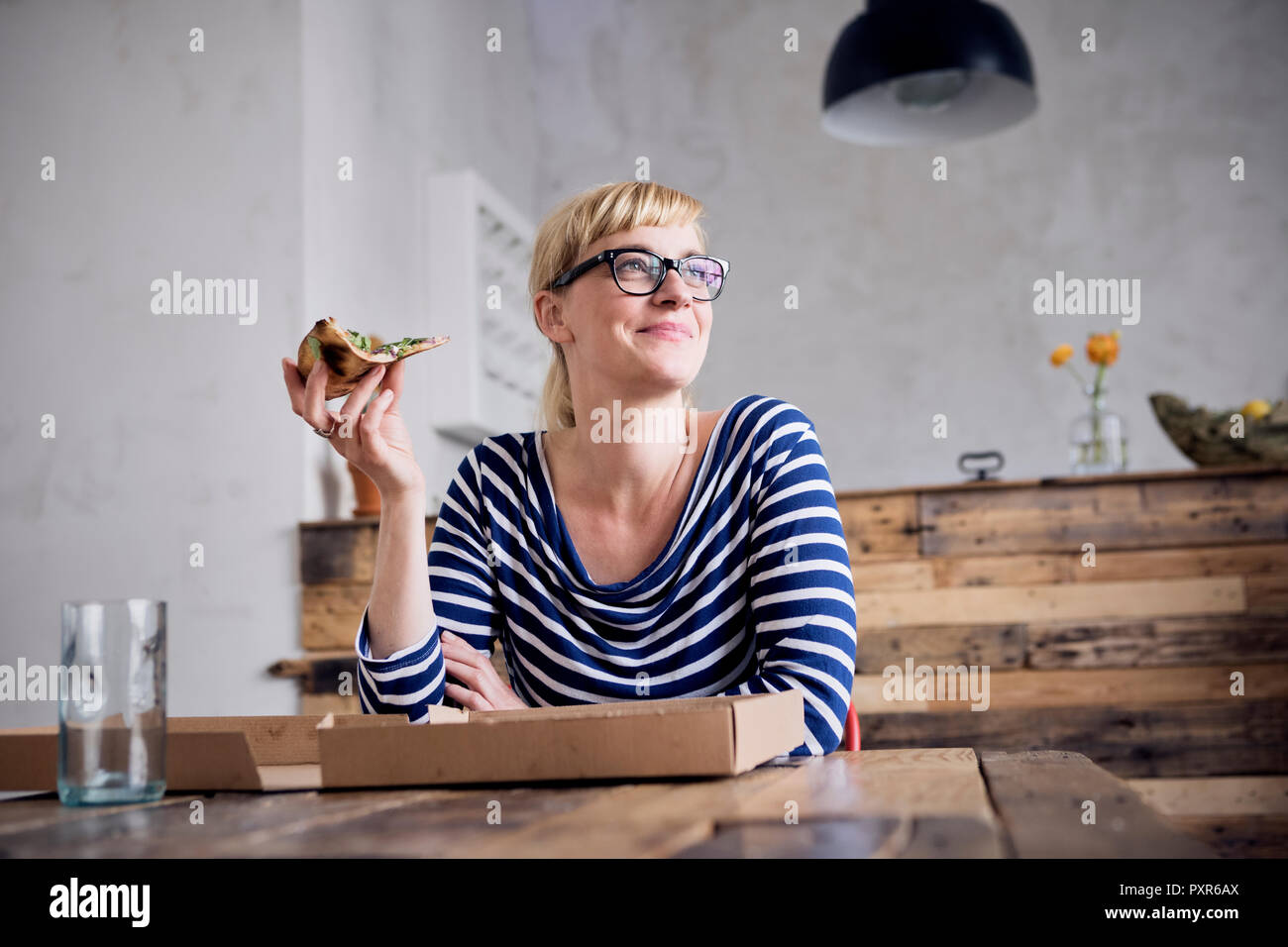 Portrait of smiling woman eating pizza Stock Photo