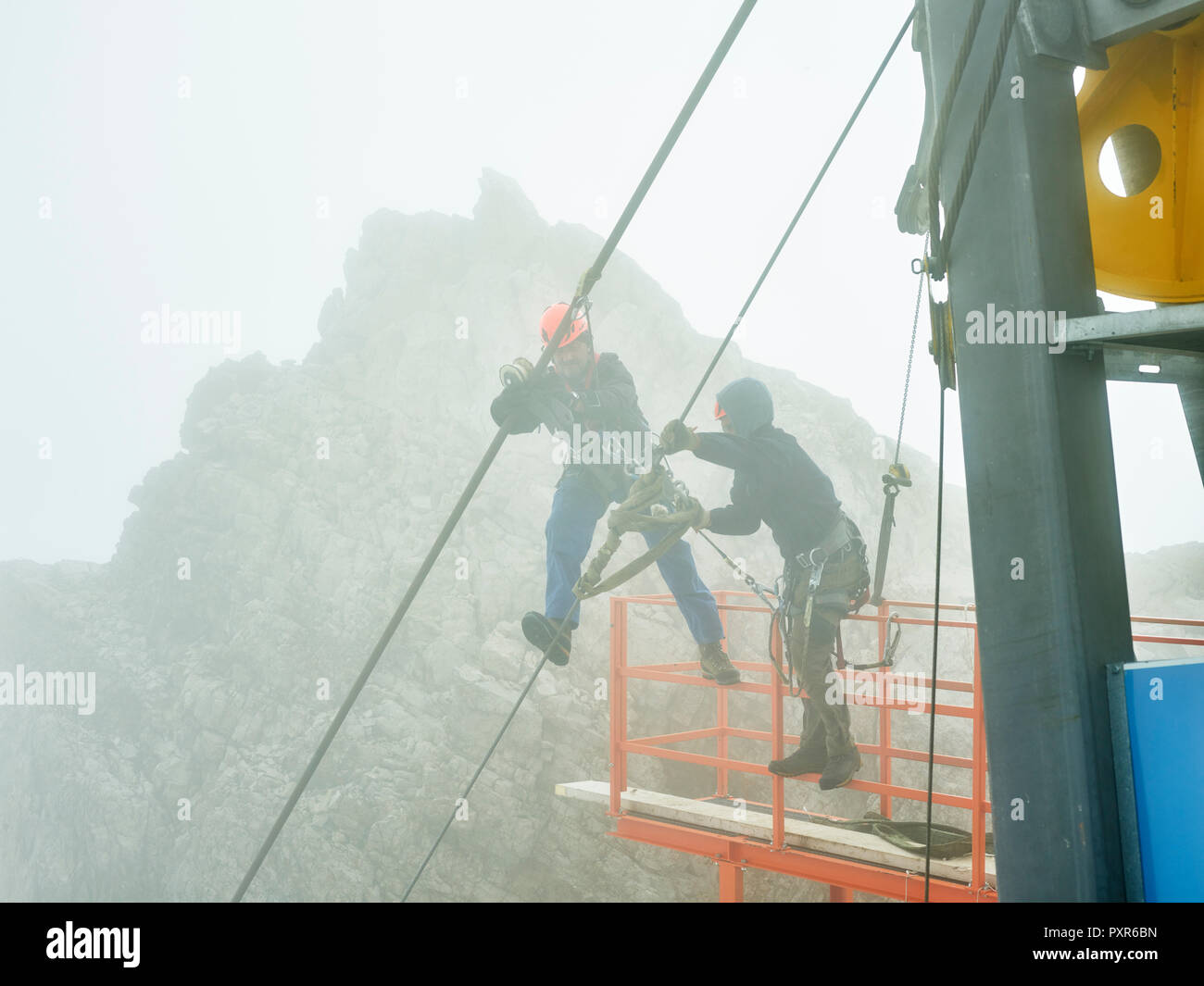 Germany, Bavaria, Garmisch-Partenkirchen, Zugspitze, installers working on steel rope of a goods cable lift Stock Photo