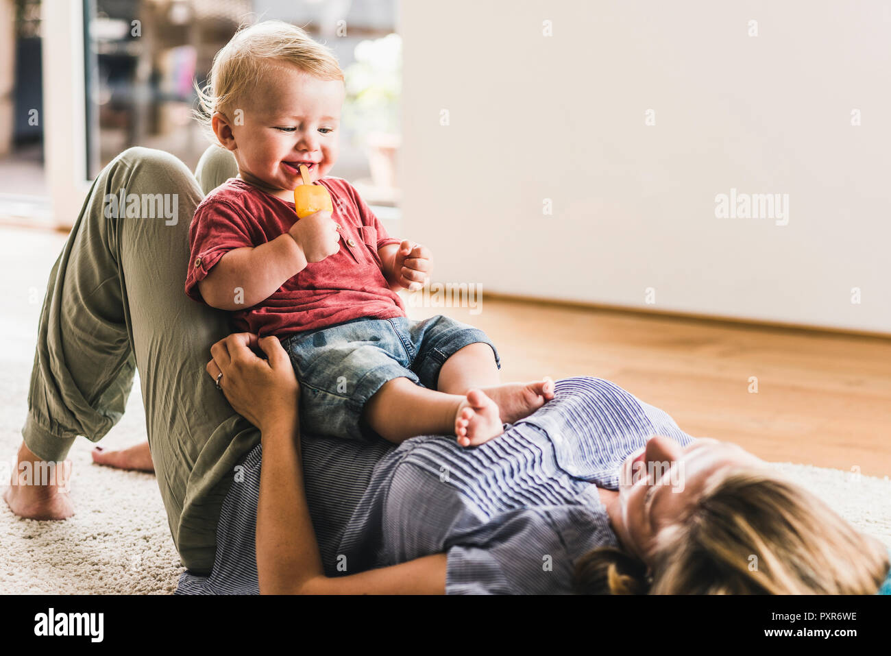 Mother and son at home eating ice lolly Stock Photo