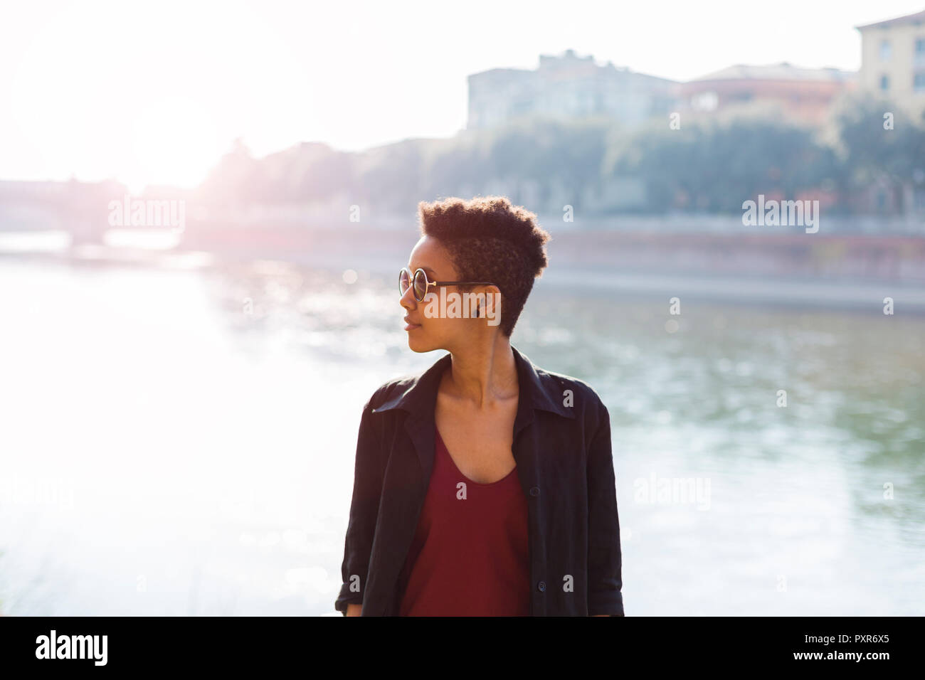 Italy, Verona, young woman in front of Adige River Stock Photo