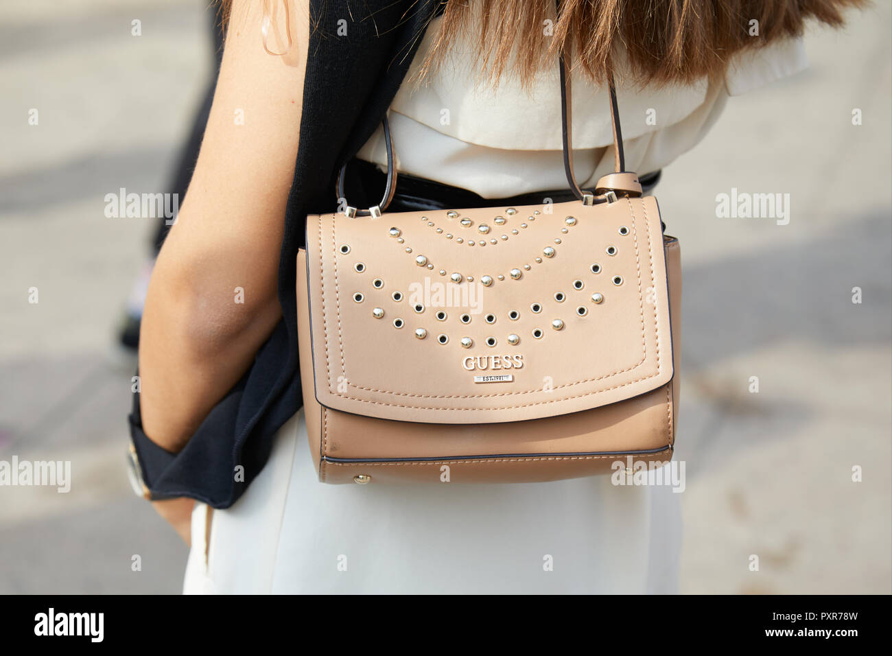 MILAN, ITALY - SEPTEMBER 22, 2018: Woman with beige leather Guess bag with  studs before Gabriele Colangelo fashion show, Milan Fashion Week street sty  Stock Photo - Alamy