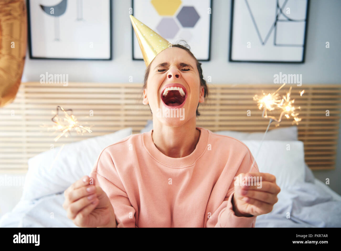 Cheerful woman during her birthday with sparklers Stock Photo