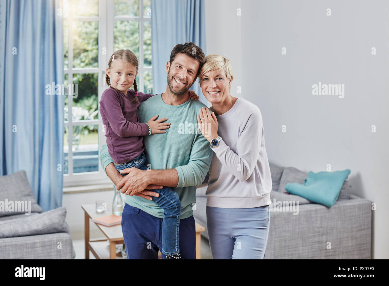 Portrait of happy parents with daughter at home Stock Photo
