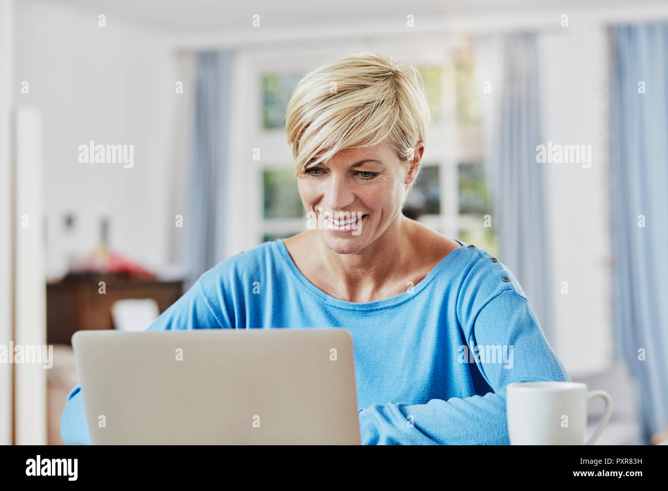 Woman using laptop at home Stock Photo