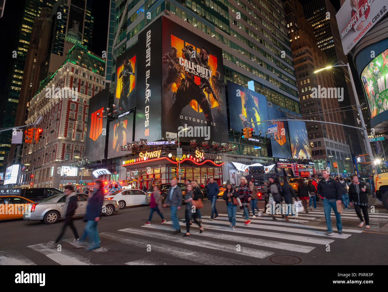 Tourists in Times Square go about the business of being tourists below a billboard for the Activision videogame 'Call of Duty Black Ops', seen on Tuesday, October 16, 2018. (© Richard B. Levine) Stock Photo
