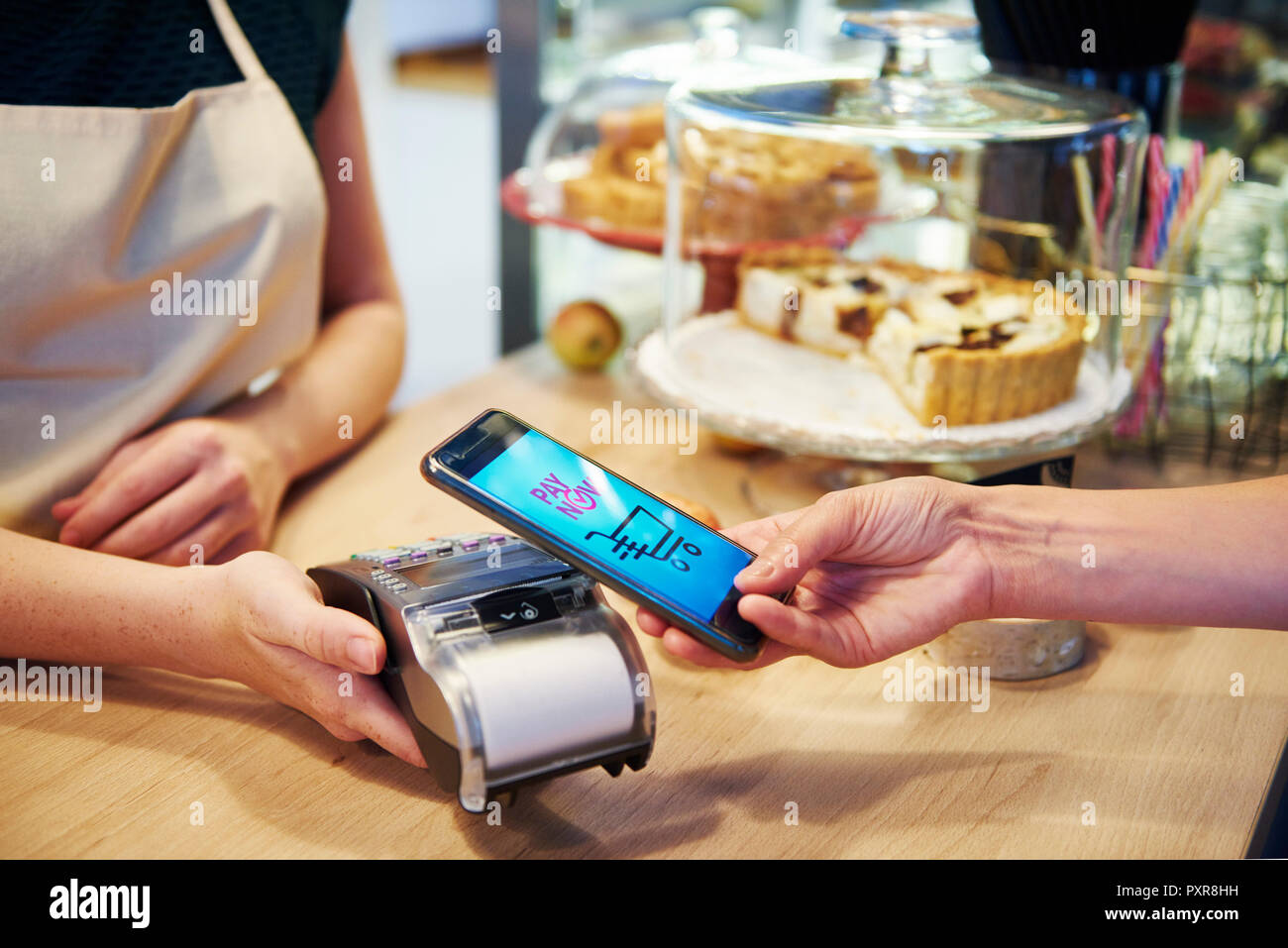 Customer paying cashless with smartphone in a cafe Stock Photo