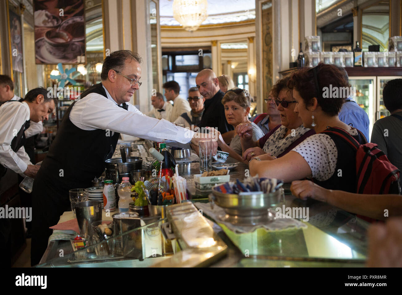 Waiter serving coffee to customers in Gambrinus Cafe in Naples Stock Photo
