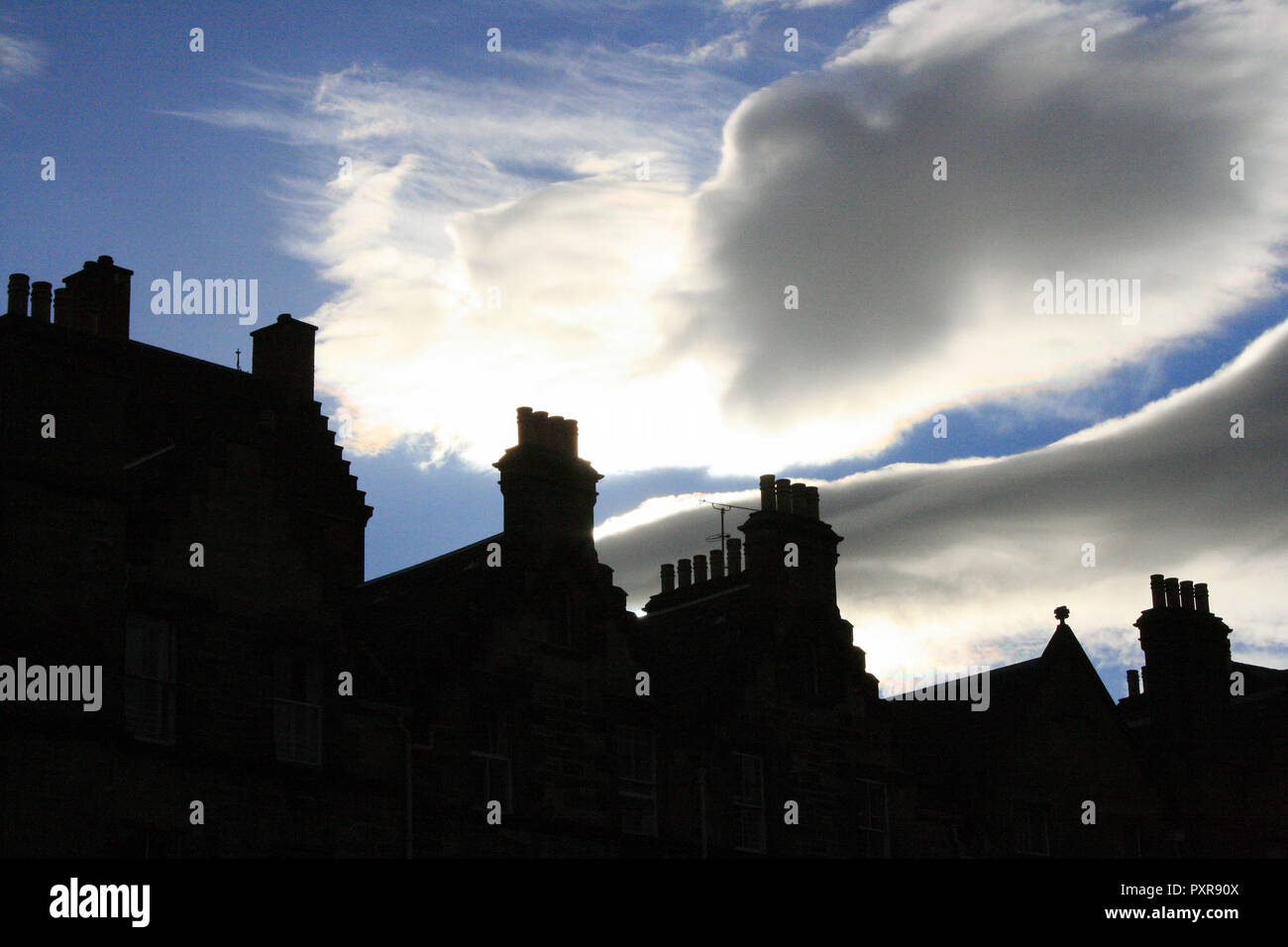Chimney pipes silhouetted against a dramatic blue cloudy sky, Edinburgh, Scotland Stock Photo