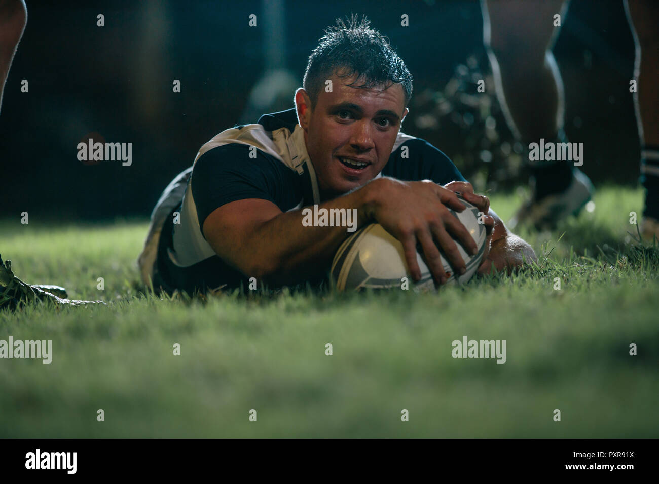 Rugby player scores a touchdown during the game. Rugby player making a touch down during the match. Stock Photo