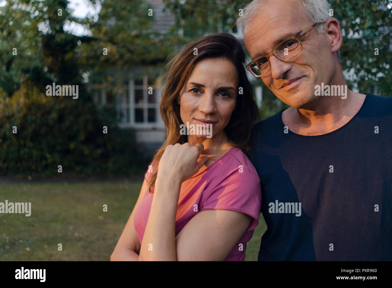 Portrait of smiling mature couple in garden of their home Stock Photo ...