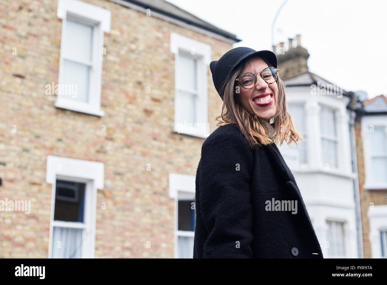 Portrait of woman dressed in black sticking out tongue Stock Photo