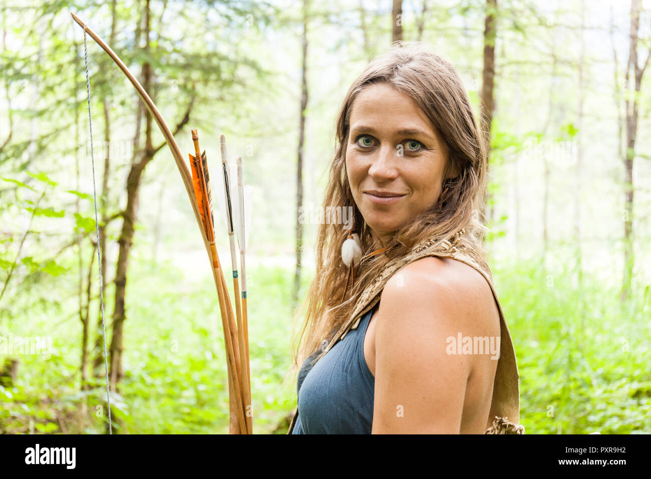 Portrait of smiling archeress in a forest Stock Photo