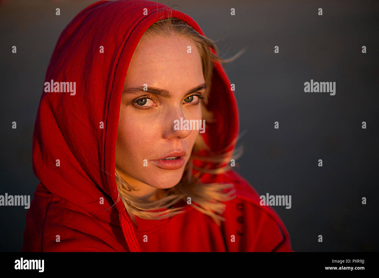 Portrait young woman wearing red hooded jacket evening light hi-res ...