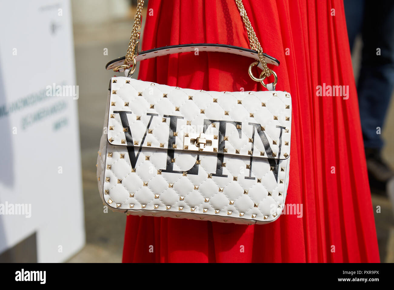MILAN, ITALY - SEPTEMBER 22, 2018: Woman with red skirt and white leather  Valentino bag with studs before Philosophy fashion show, Milan Fashion Week  Stock Photo - Alamy