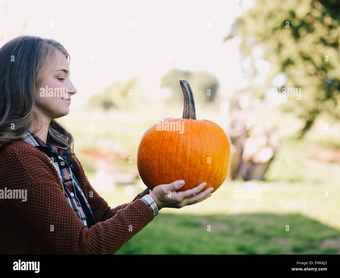 Proud woman holding big pumpkin Stock Photo