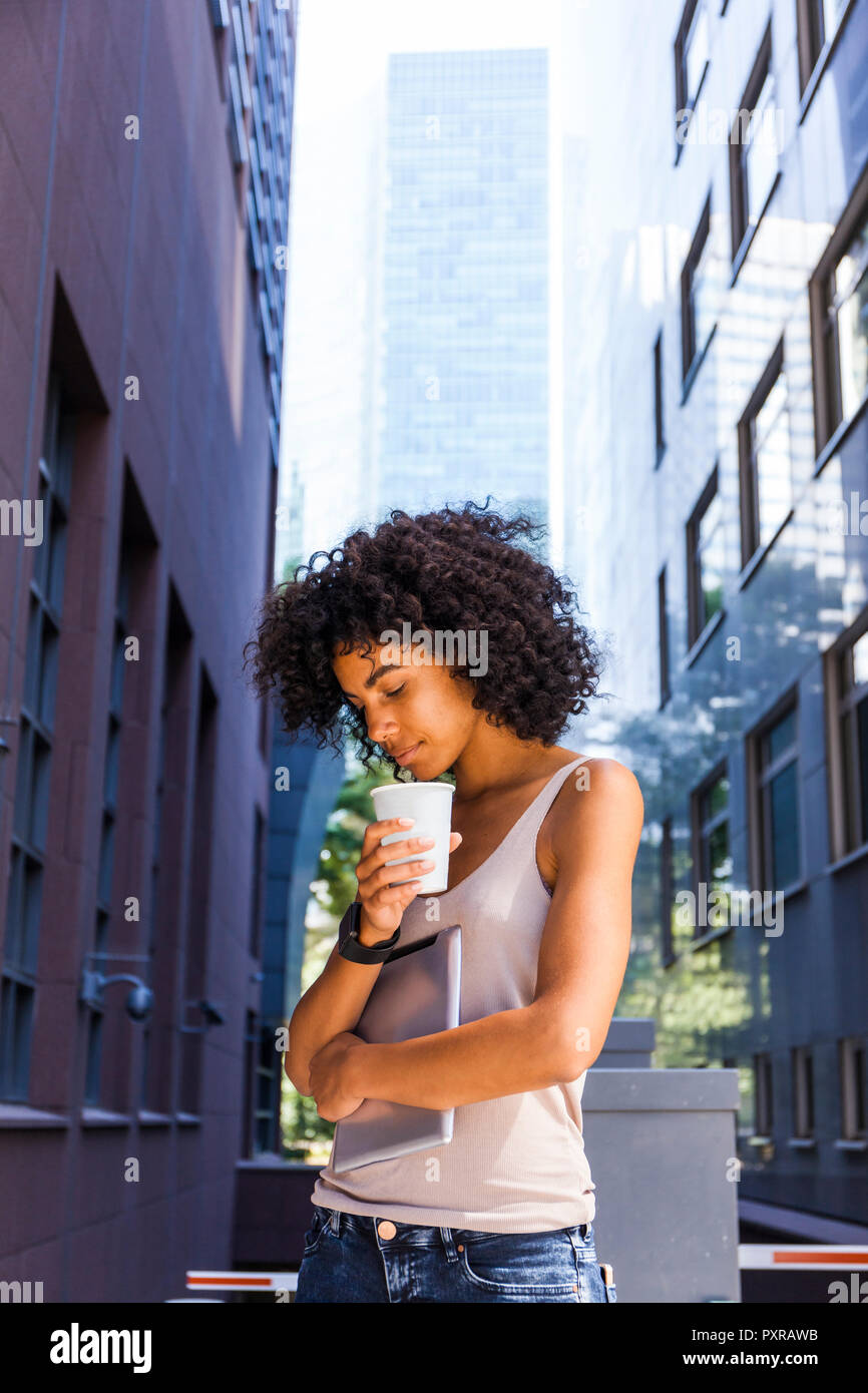 Germany, Frankfurt, young woman with tablet and coffee to go in the city Stock Photo