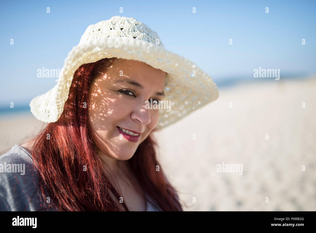 Portrait of smiling woman wearing summer hat on the beach Stock Photo ...