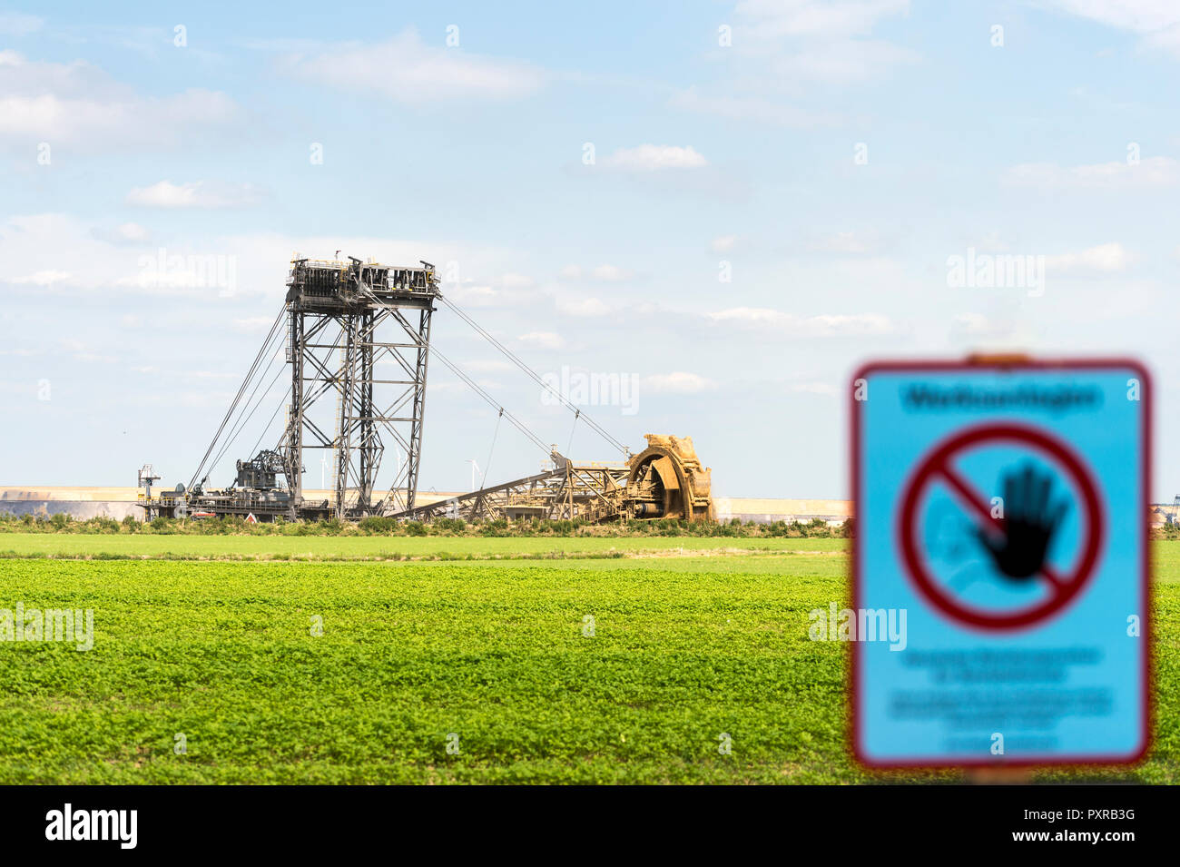Germany, Garzweiler surface mine, warning sign and giant bucket-wheel excavator Stock Photo