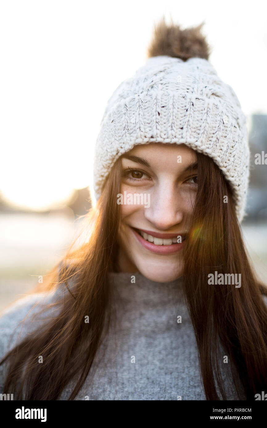 Portrait Of Smiling Young Woman Wearing Bobble Hat In Winter Stock