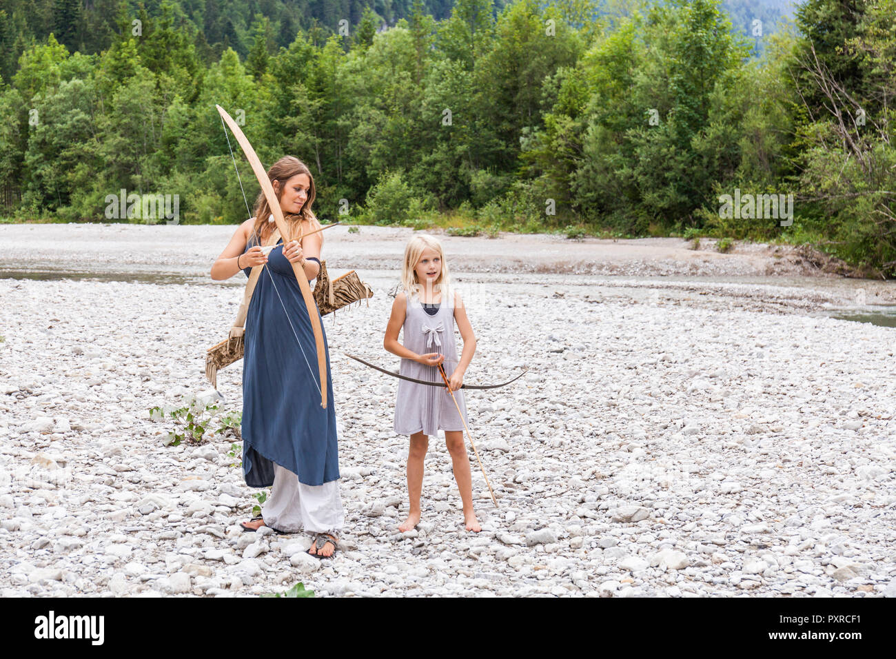 Mother and daughter with bow and arrow in the nature Stock Photo