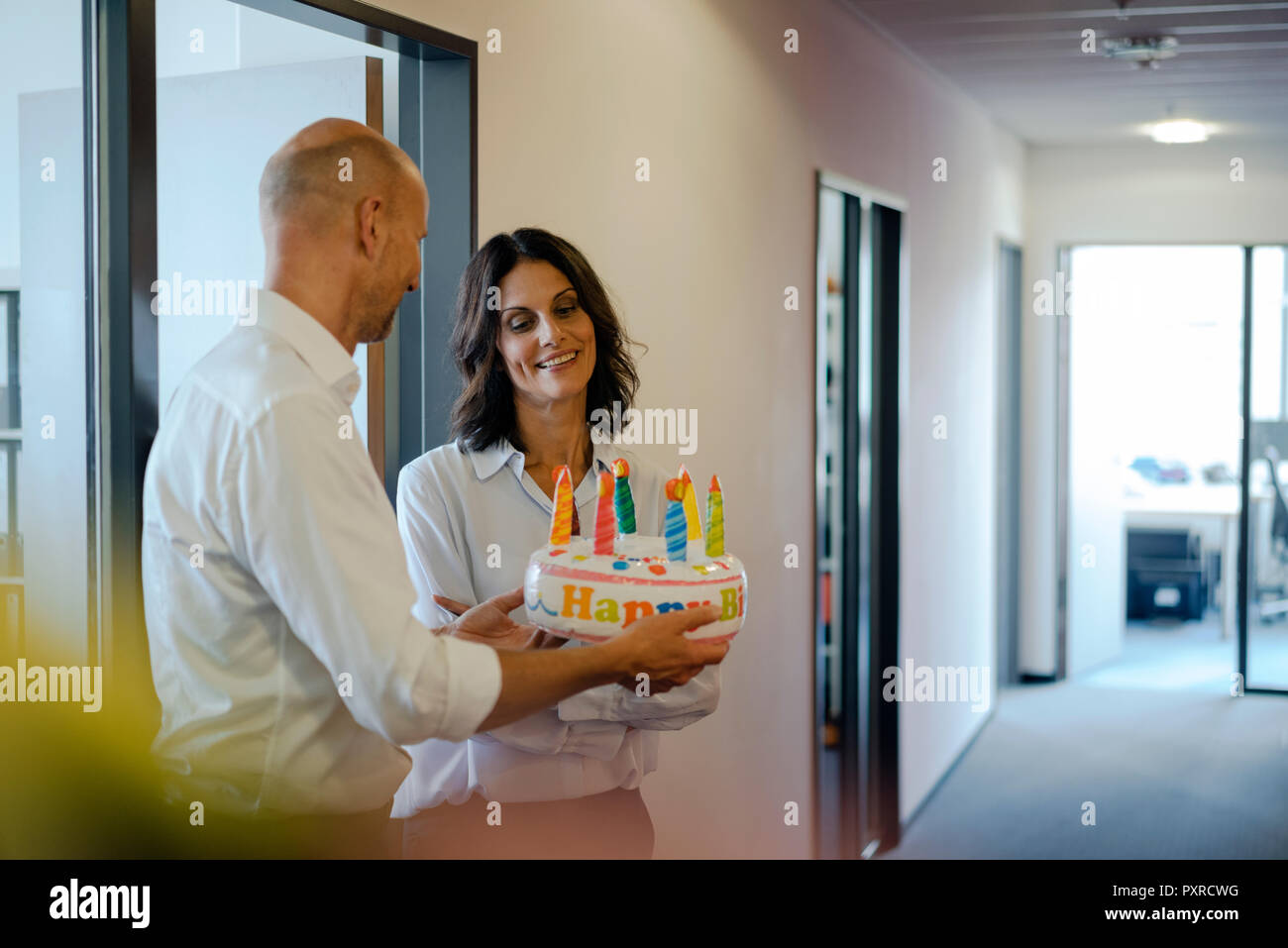 Businessman gifting his colleague with a birthday cake in office Stock Photo