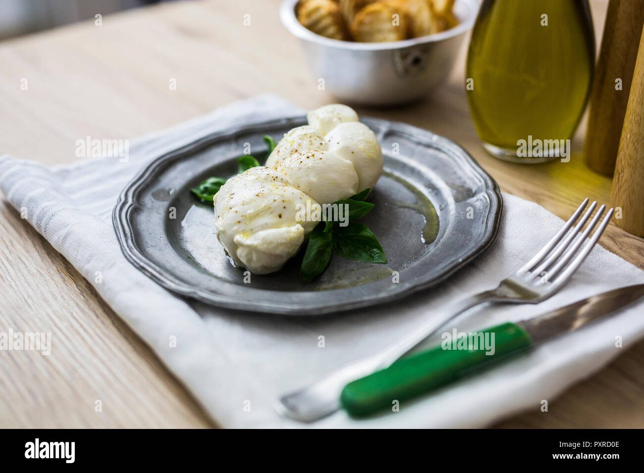 Mozzarella braid and basil on plate Stock Photo