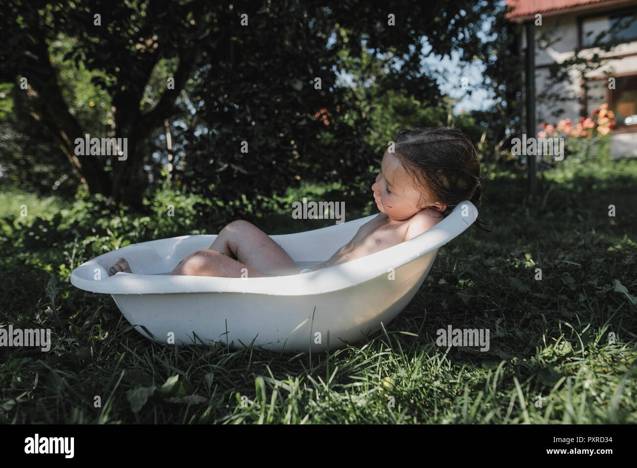 Little girl relaxing in bath tub in garden Stock Photo Alamy
