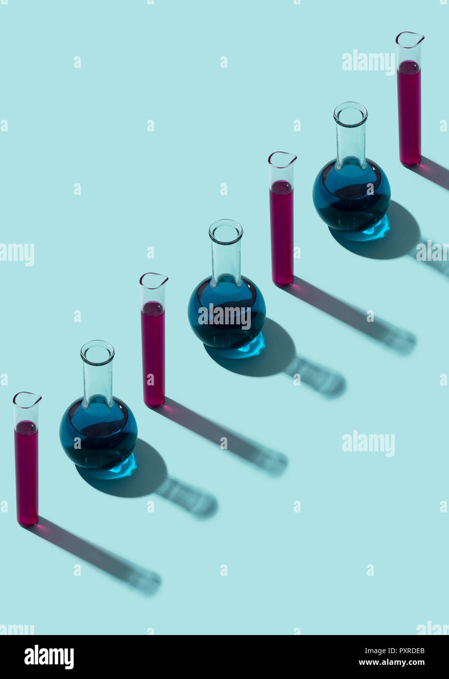 Row of test tubes with liquid, cyan background Stock Photo