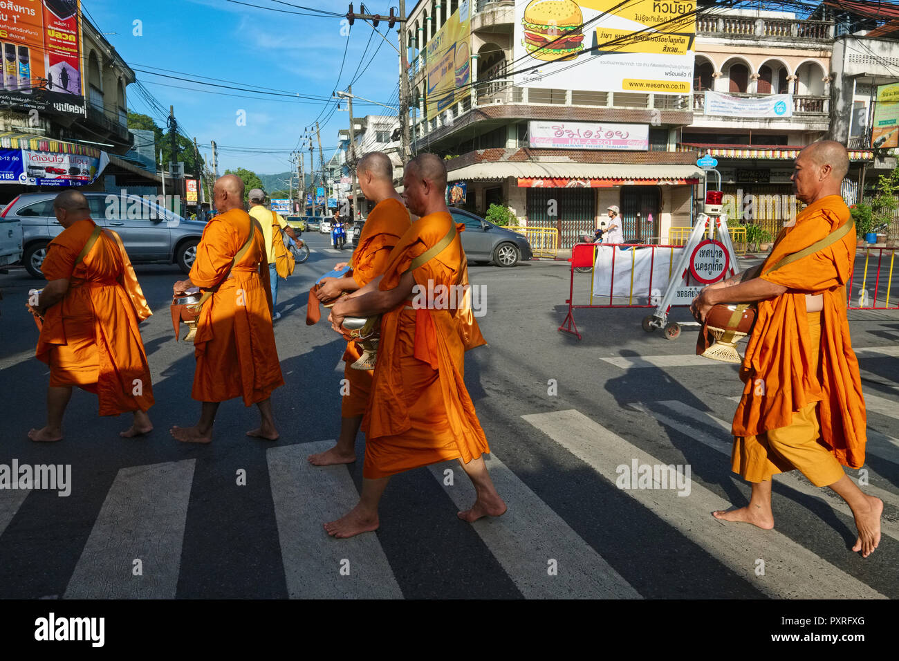 Monks residing by Phuket's Big Buddha on their early morning alms round, in Phuket Town, Phuket, Thailand, Stock Photo