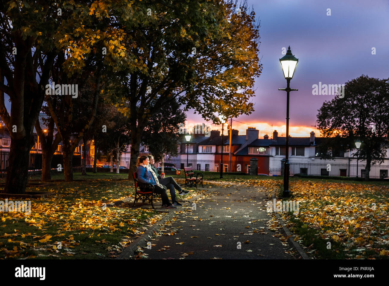 Cork, Ireland. 24th October, 2018. Edel Murphy and Niamh McMullen from Victoria Road, take a moment on their way to work to enjoy the peace and tranquillity on a mild October morning in Shalom Park, Cork City, Ireland. Credit: David Creedon/Alamy Live News Stock Photo