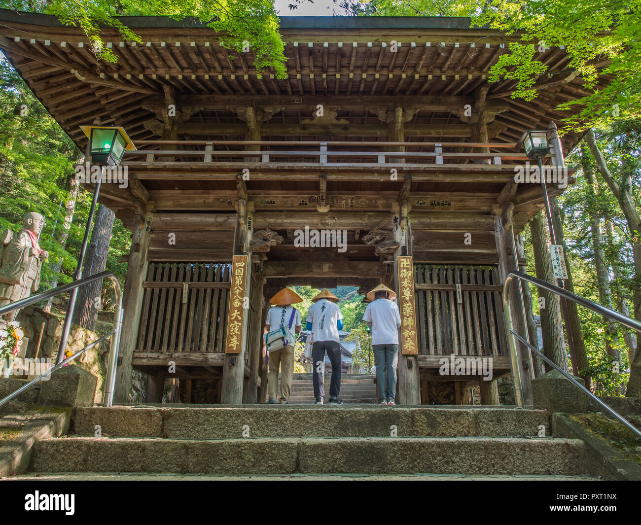 3 three henro pilgrims at gate to Okuboji temple 88, Shikoku 88 temple pilgrimage, Kagawa, Japan Stock Photo